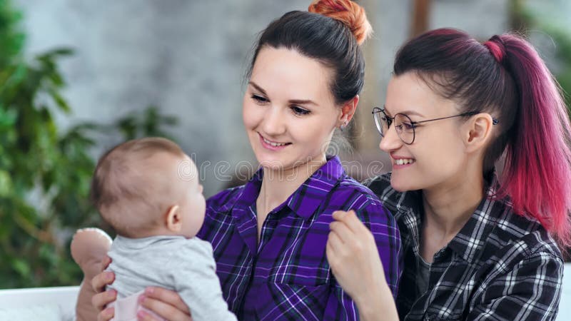 Parents féminins heureux tenant peu de fils jouant et admirant le plan rapproché moyen de bébé mignon banque de vidéos
