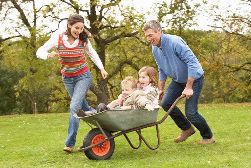 Parents Giving Children Ride In Wheelbarrow royalty free stock photos