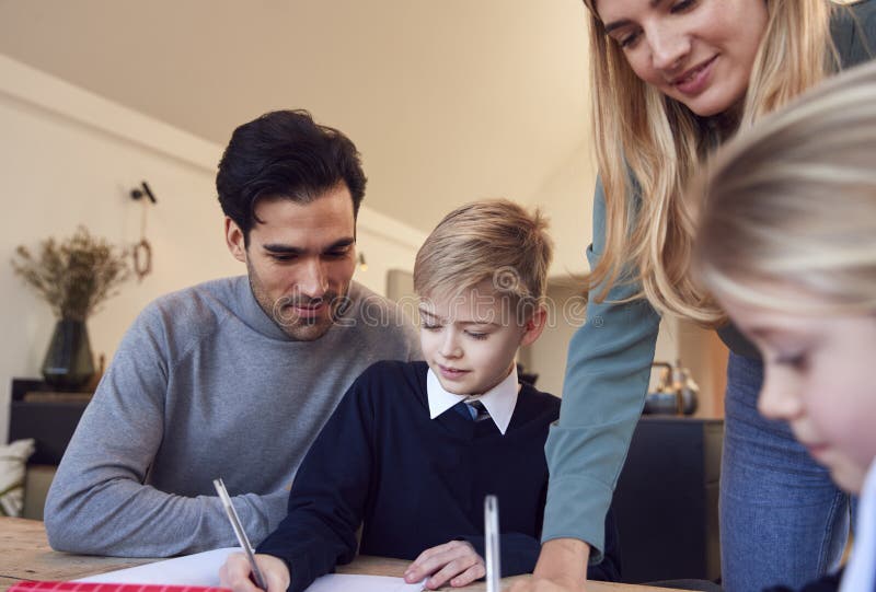 Parents Helping Son and Daughter Wearing School Uniform with Homework
