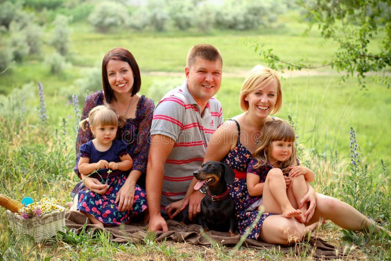Parents heureux et leurs enfants sur le pique-nique images stock Parents heureux et leurs enfants sur le pique-nique images stock