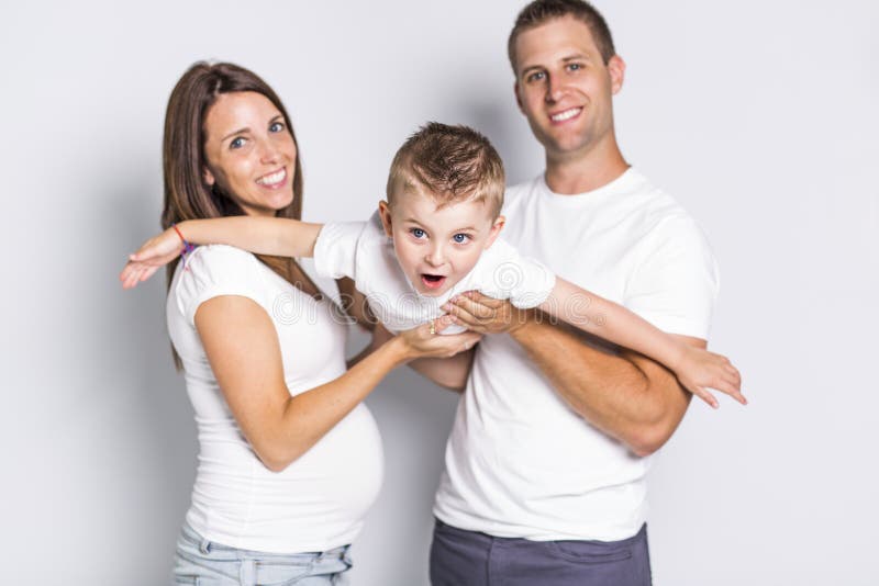 Parents heureux jouant l'avion avec leur garçon d'enfant d'isolement sur le fond blanc photos stock Parents heureux jouant l'avion avec leur garçon d'enfant d'isolement sur le fond blanc photos stock