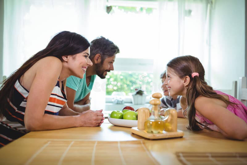 Parents and kids looking face to face and smiling