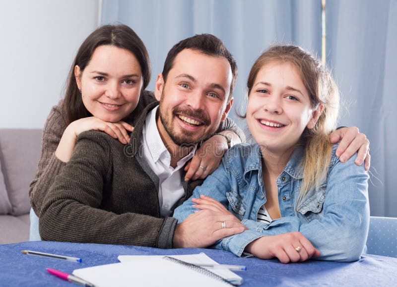 Parents la figlia d'aiuto con compito fotografia stock Parents la figlia d'aiuto con compito fotografia stock