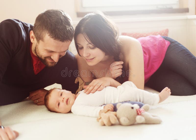 Happy young parents with their little baby girl at home. Happy young parents with their little baby girl at home