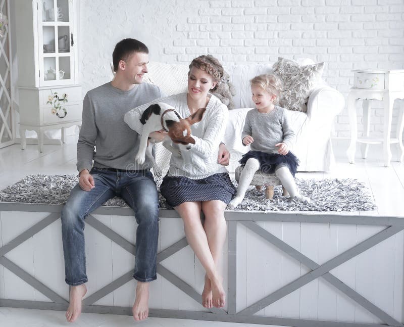 Parents and little girl playing with a dog stock photography Parents and little girl playing with a dog stock photography