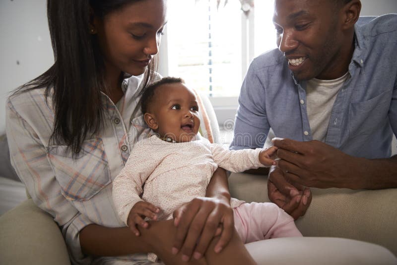 Parents Sitting in Nursery with Baby Daughter Stock Image Image of