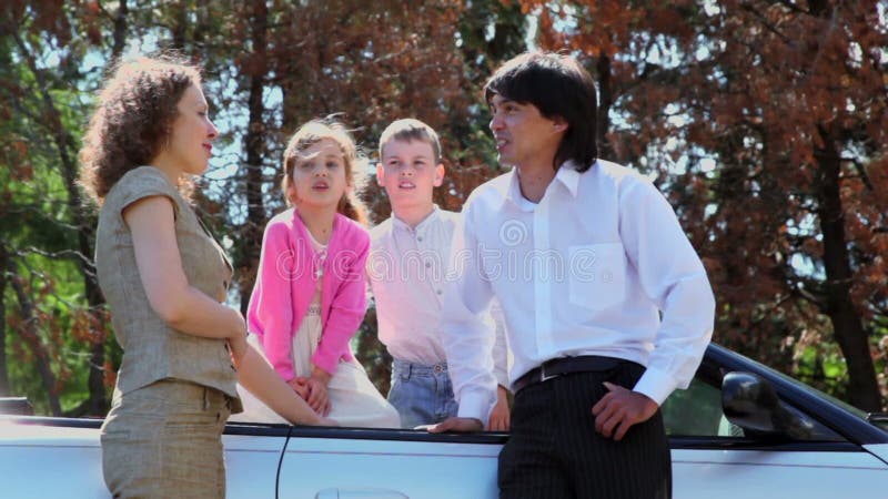 Parents talk with their kids in cabriolet at sunny stock footage