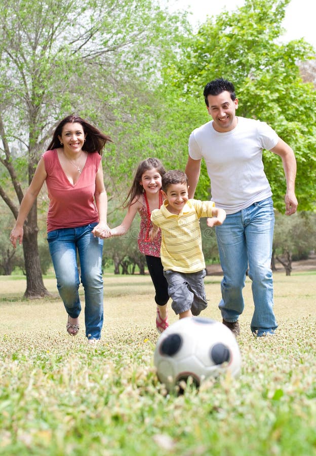 Parents and two young children playing soccer