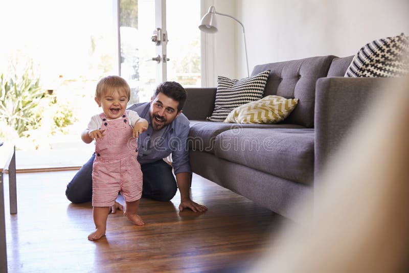 Parents Watching Baby Daughter Take First Steps At Home royalty free stock images Parents Watching Baby Daughter Take First Steps At Home royalty free stock images