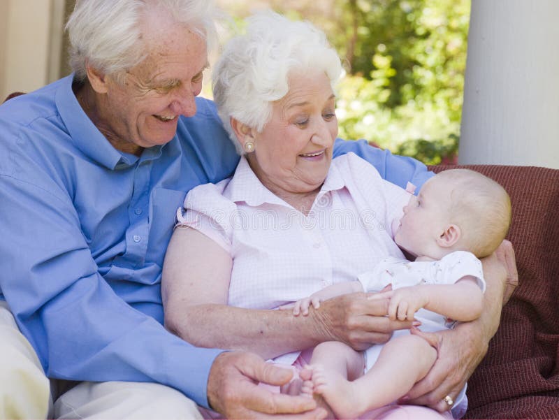 Parents à l'extérieur sur le patio avec la chéri images libres de droits Parents à l'extérieur sur le patio avec la chéri images libres de droits
