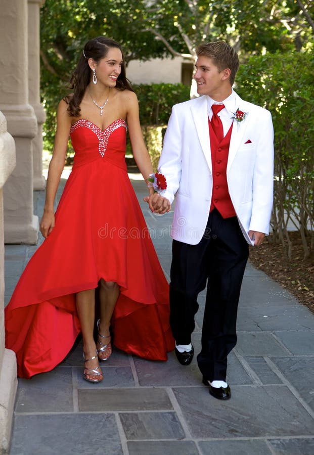 Pares adolescentes que vão ao baile de finalistas que anda e que sorri em se imagens de stock royalty free Pares adolescentes que vão ao baile de finalistas que anda e que sorri em se imagens de stock royalty free