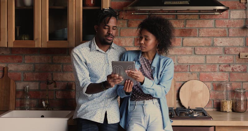 Pares africanos mediante el equipo de comprimidos que se coloca en la cocina nacional