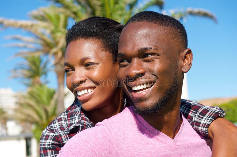 Pares afro-americanos novos alegres que sorriem fora imagens de stock royalty free Pares afro-americanos novos alegres que sorriem fora imagens de stock royalty free
