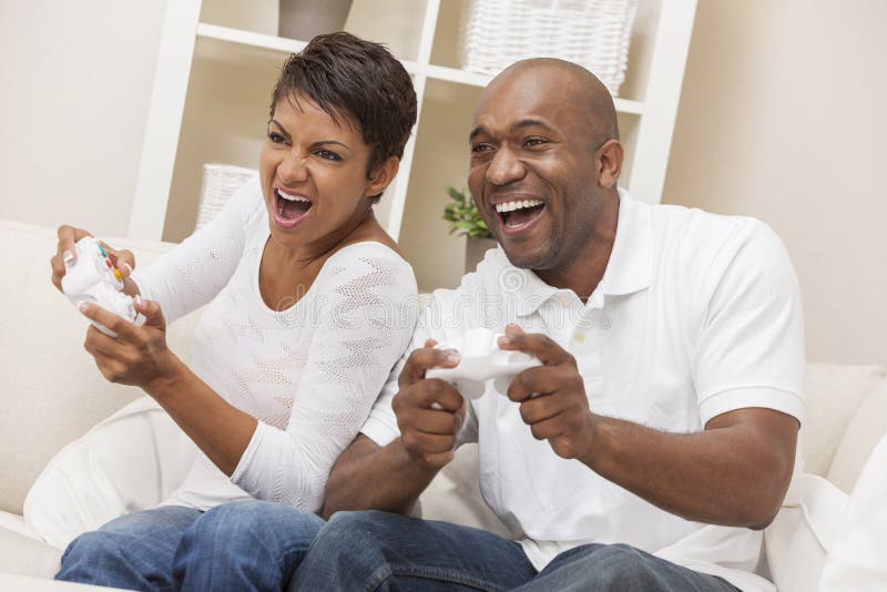 Pares afro-americanos que têm o divertimento que joga o jogo video do console imagens de stock Pares afro-americanos que têm o divertimento que joga o jogo video do console imagens de stock