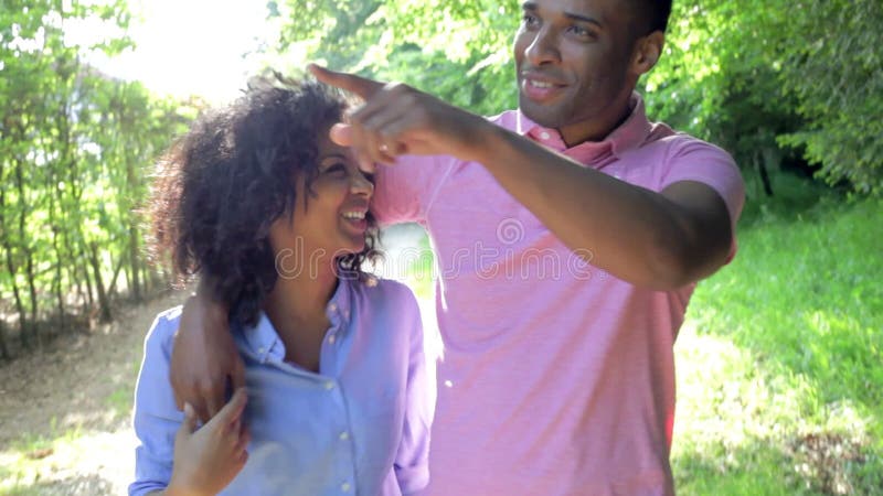 Pares afroamericanos jovenes que caminan en campo