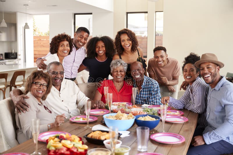 Pares afroamericanos mayores que se sientan en la tabla de cena que celebra en casa con la familia, foco selectivo