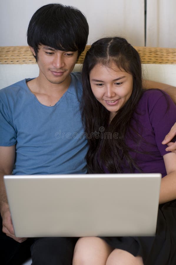 Jovem casal asiático com computador imagens de stock royalty free