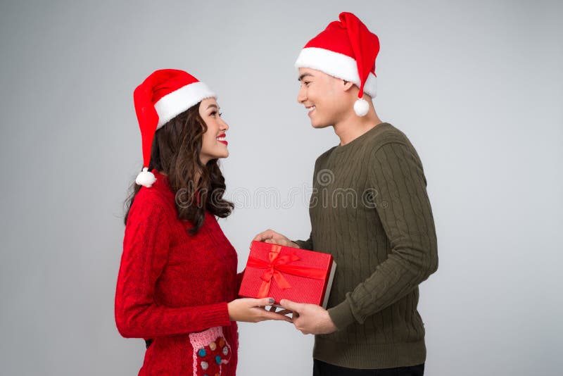 Pares asiáticos que se dan los regalos de la Navidad foto de archivo Pares asiáticos que se dan los regalos de la Navidad foto de archivo