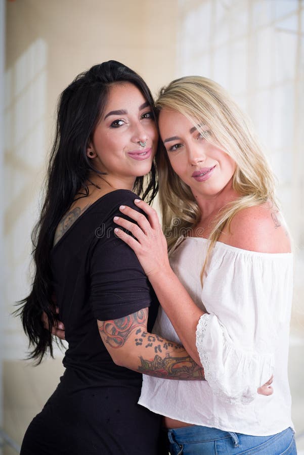 Pares atractivos hermosos de los amantes de las lesbianas en un cuarto en la mañana, en un fondo blanco fotos de archivo Pares atractivos hermosos de los amantes de las lesbianas en un cuarto en la mañana, en un fondo blanco fotos de archivo