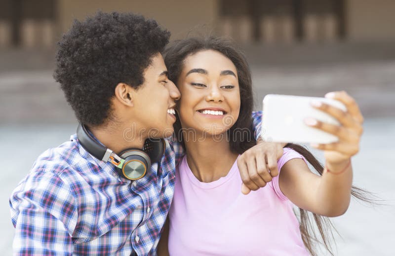 Pares cariñosos jovenes que hacen el selfie en cámara del smartphone fotos de archivo Pares cariñosos jovenes que hacen el selfie en cámara del smartphone fotos de archivo