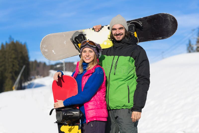 Pares com férias extremas de sorriso do esporte do homem e da mulher de Ski Resort Snow Winter Mountain do Snowboard imagem de stock royalty free Pares com férias extremas de sorriso do esporte do homem e da mulher de Ski Resort Snow Winter Mountain do Snowboard imagem de stock royalty free