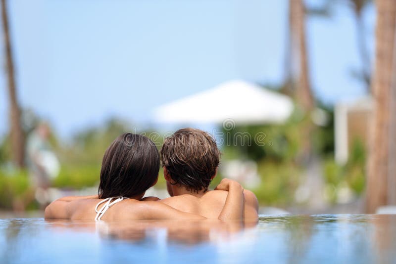 Pares da lua de mel que relaxam junto - a piscina imagem de stock royalty free Pares da lua de mel que relaxam junto - a piscina imagem de stock royalty free