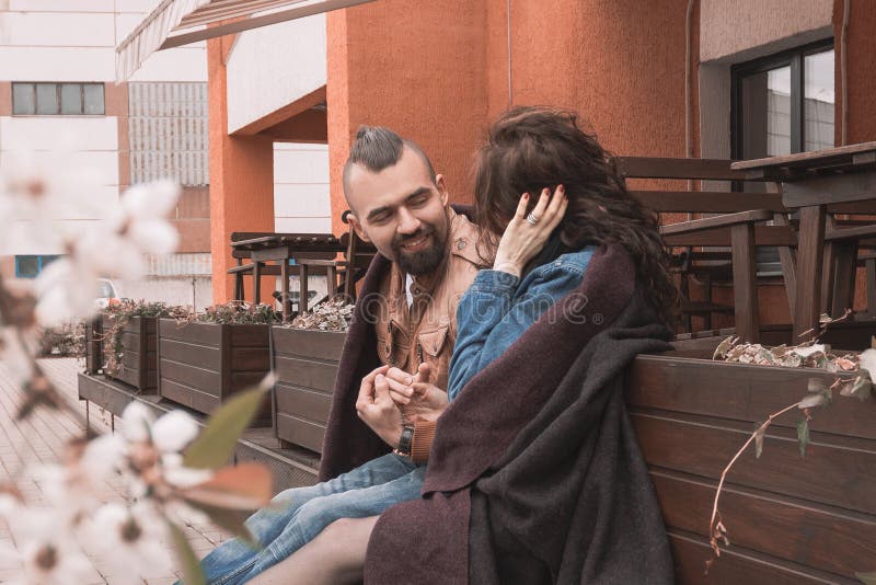 Pares de amor que hablan mientras que se sienta cerca de un café al aire libre foto de archivo Pares de amor que hablan mientras que se sienta cerca de un café al aire libre foto de archivo