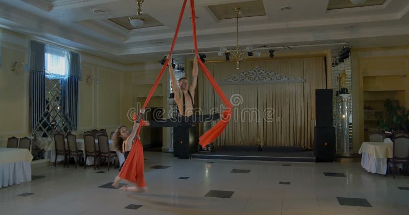 Pares de bailarines en la seda aérea roja, contorsión aérea metrajes
