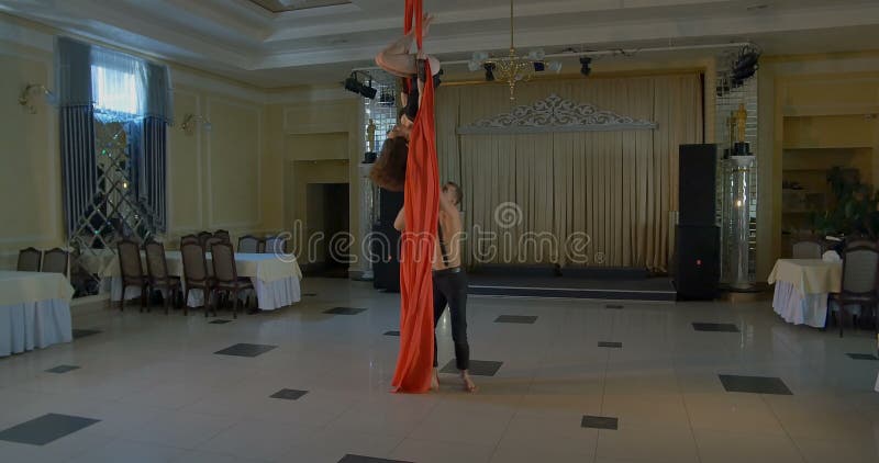 Pares de bailarines en la seda aérea roja, contorsión aérea metrajes