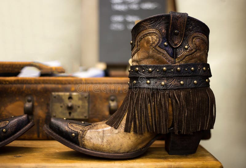 Pares de botas de couro marrons feitos a mão da vaqueira com suitca do vintage
