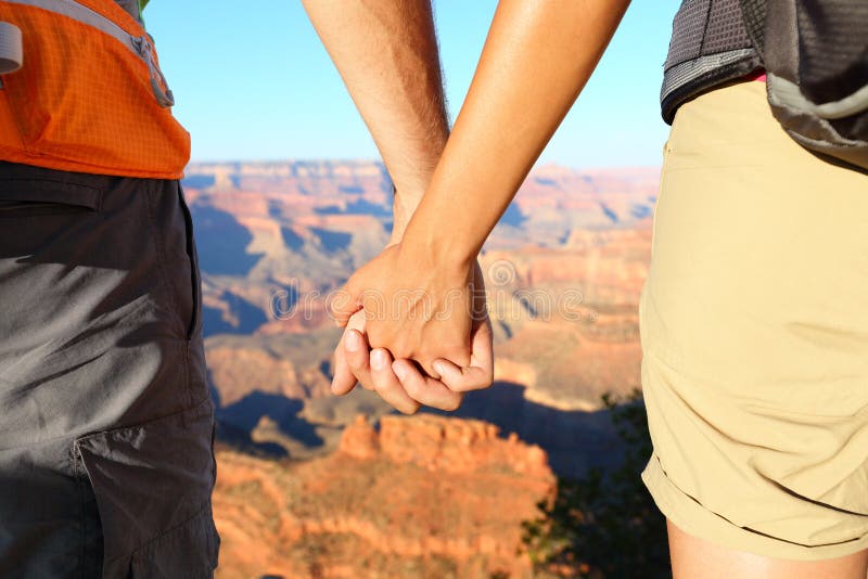 Pares de caminhada românticos que guardam as mãos, Grand Canyon fotografia de stock Pares de caminhada românticos que guardam as mãos, Grand Canyon fotografia de stock