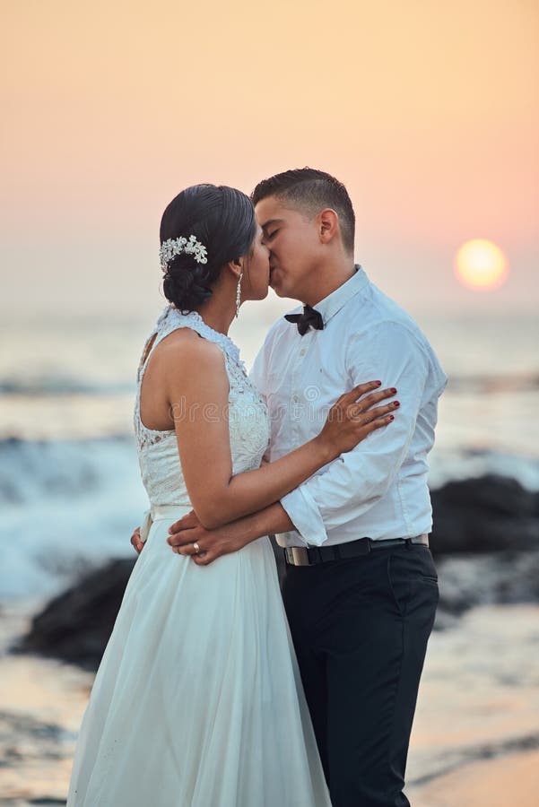 Pares de la boda que se besan en la playa imágenes de archivo libres de regalías Pares de la boda que se besan en la playa imágenes de archivo libres de regalías