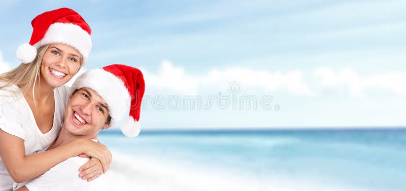 Pares de Santa do Natal feliz na praia. fotos de stock royalty free