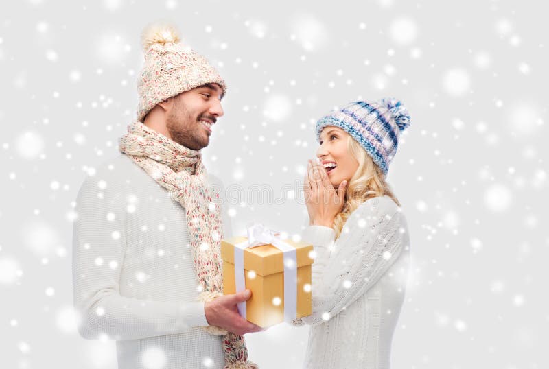 Pares de sorriso na roupa do inverno com caixa de presente imagem de stock Pares de sorriso na roupa do inverno com caixa de presente imagem de stock