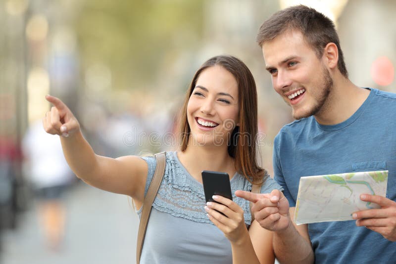 Pares de turistas que verificam o lugar na rua imagem de stock royalty free Pares de turistas que verificam o lugar na rua imagem de stock royalty free