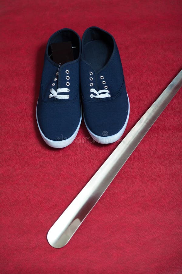 Pares de zapatillas de deporte y de cuerno azules del zapato en fondo rojo imagenes de archivo Pares de zapatillas de deporte y de cuerno azules del zapato en fondo rojo imagenes de archivo