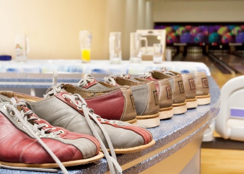 Pairs of bowling shoes lined up in shoe rack. Pairs of bowling shoes lined up in shoe rack