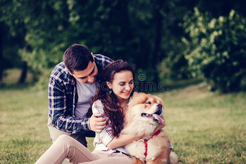 Pares e cão novos bonitos imagens de stock Pares e cão novos bonitos imagens de stock