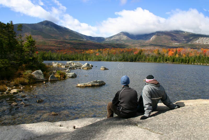 A young couple enjoy the view of Mount Katahdin while hiking in Baxter State Park, Maine, USA. A young couple enjoy the view of Mount Katahdin while hiking in Baxter State Park, Maine, USA.