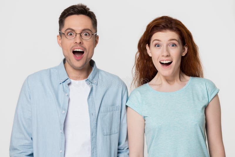 Pares emocionados con las caras felices sorprendentes por venta increíble imagen de archivo libre de regalías Pares emocionados con las caras felices sorprendentes por venta increíble imagen de archivo libre de regalías