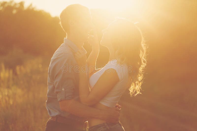Pares en amor en la puesta del sol imagen de archivo