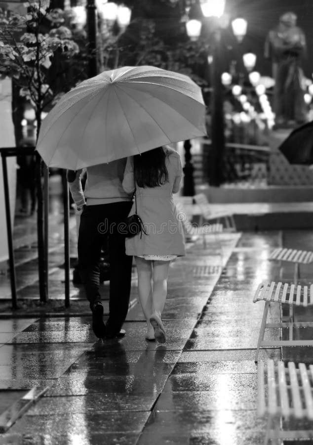 Pares en el amor que camina en la lluvia foto de archivo Pares en el amor que camina en la lluvia foto de archivo