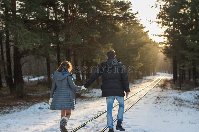 Pares en el parque del invierno que camina por el ferrocarril Familia al aire libre Amor foto de archivo Pares en el parque del invierno que camina por el ferrocarril Familia al aire libre Amor foto de archivo