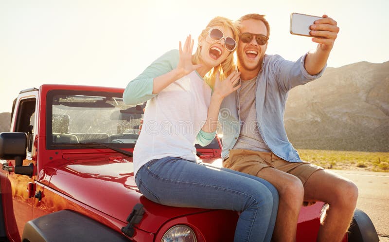 Pares en el viaje por carretera Sit On Convertible Car Taking Selfie fotografía de archivo