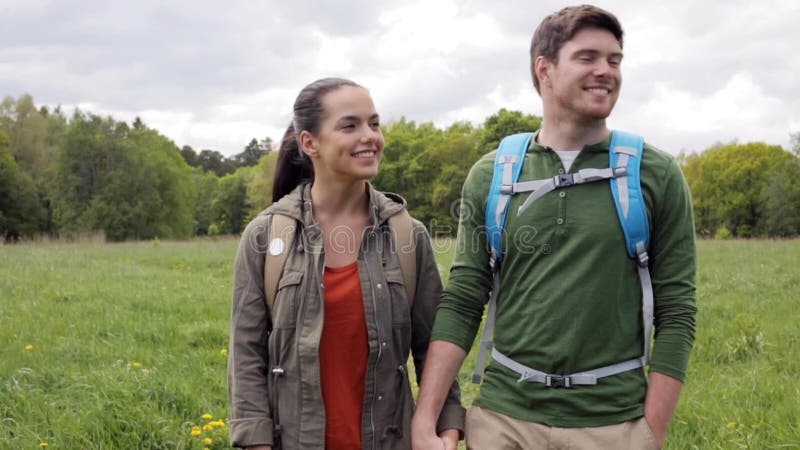 Pares felices con las mochilas que caminan al aire libre 1