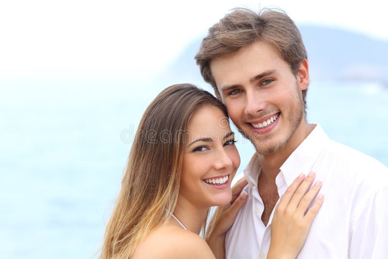 Pares felices con una sonrisa blanca que mira la cámara imagen de archivo