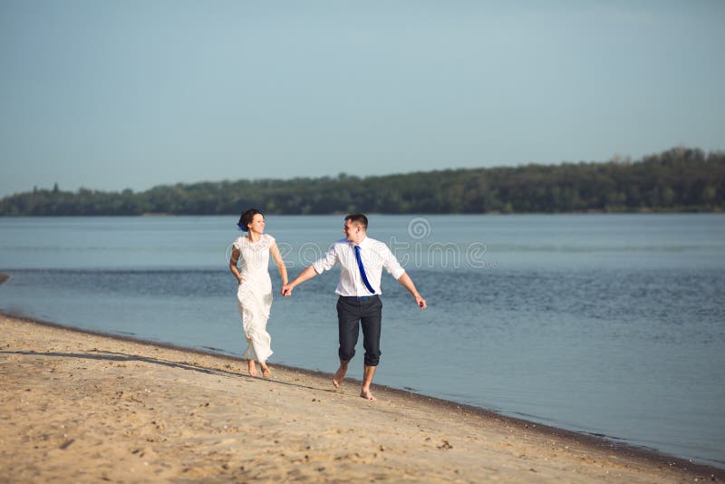 Pares felices jovenes sensuales que celebran su amor en la playa y que se divierten Imagen entonada imagenes de archivo Pares felices jovenes sensuales que celebran su amor en la playa y que se divierten Imagen entonada imagenes de archivo