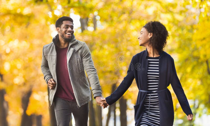Pares felices que corren junto en parque del otoño imagen de archivo libre de regalías Pares felices que corren junto en parque del otoño imagen de archivo libre de regalías