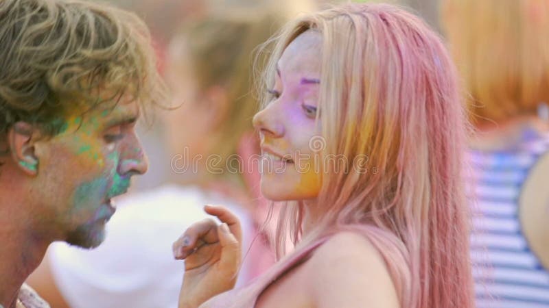 Pares felizes coloridos na dança do pó, beijando e flertando no festival hindu