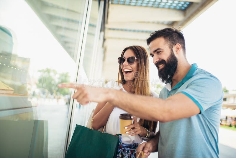 Pares felizes com os sacos de compras na cidade fotos de stock Pares felizes com os sacos de compras na cidade fotos de stock